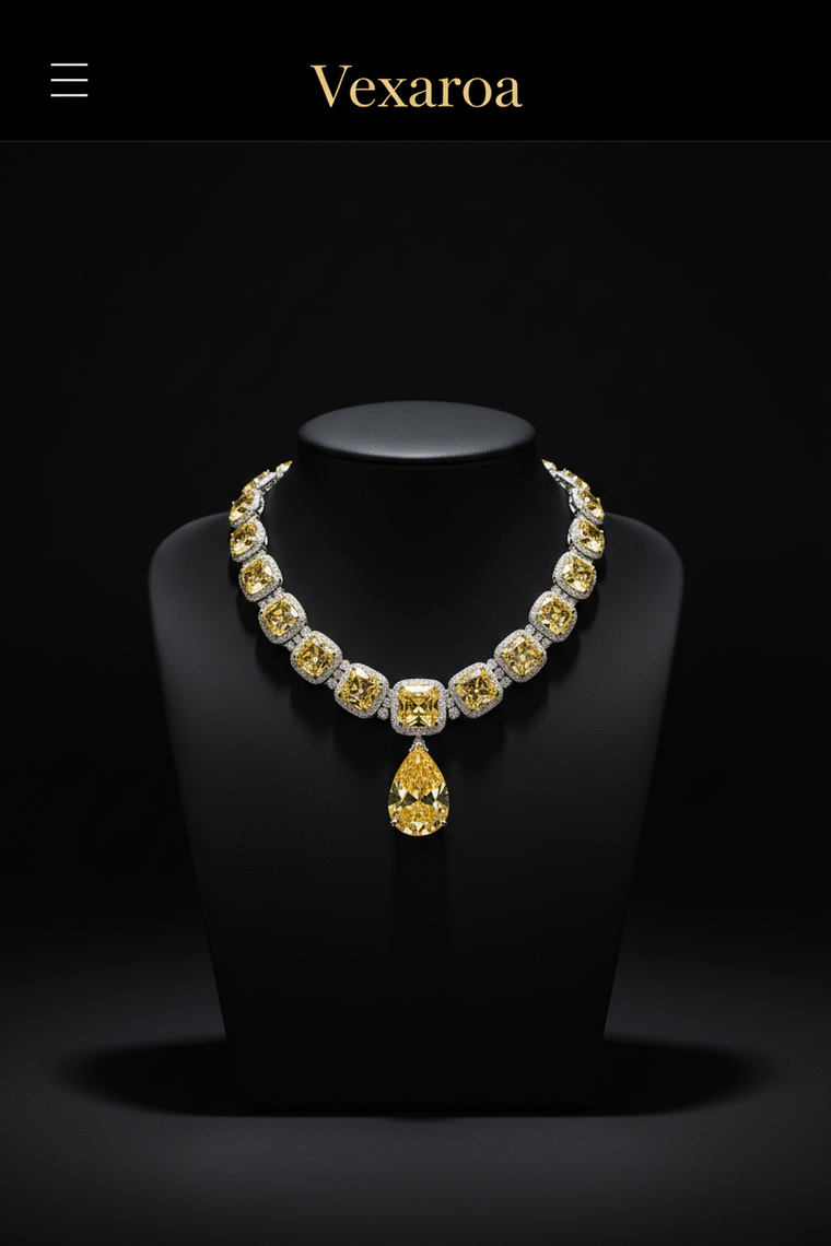 A luxury Vexaroa necklace displayed on a black jewelry bust against a dark background. The necklace features a series of round yellow gemstones set in silver-toned metal, with a large pear-shaped yellow gemstone pendant hanging at the center.