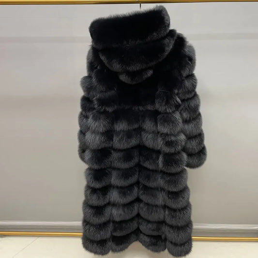 A long black fur coat with a high padded collar, hanging against a light gray wall.