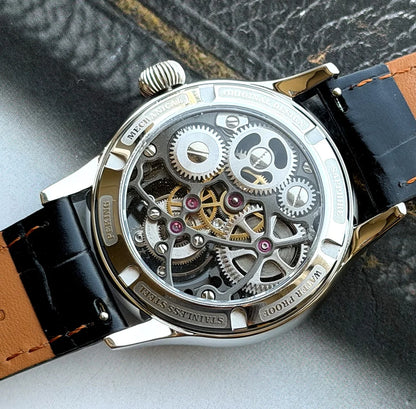 Mechanical watch with black and brown leather strap on a textured surface