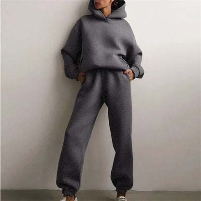 Person wearing a gray tracksuit against a plain background