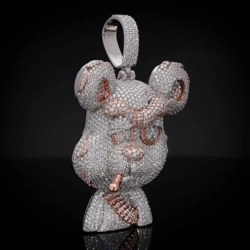 A highly detailed, mouse-shaped pendant encrusted with silver and rose gold gemstones, displayed on a reflective black surface against a dark background.