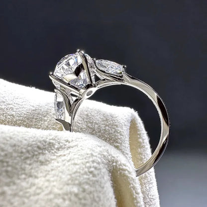 Silver ring with two large diamonds on a white towel against a dark background