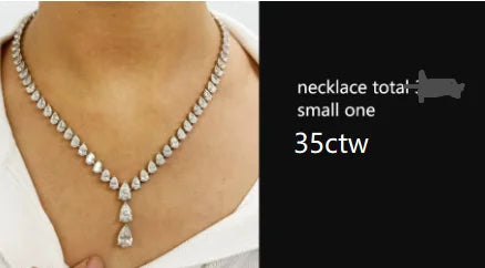 A close-up of a person wearing a silver-toned necklace with a teardrop-shaped pendant, shown against a black text panel that reads 'necklace total small one 35ctw'.