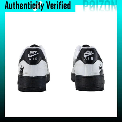 A pair of Nike Air Force 1 Low sneakers shown from the back, featuring a white leather upper with black overlays, black midsoles, and black heel tabs with white Nike branding.