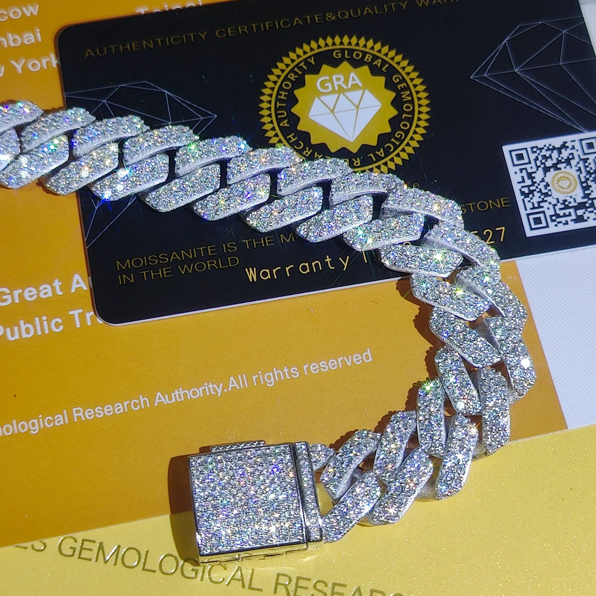 Silver chain bracelet on a yellow surface with a certification card in the background