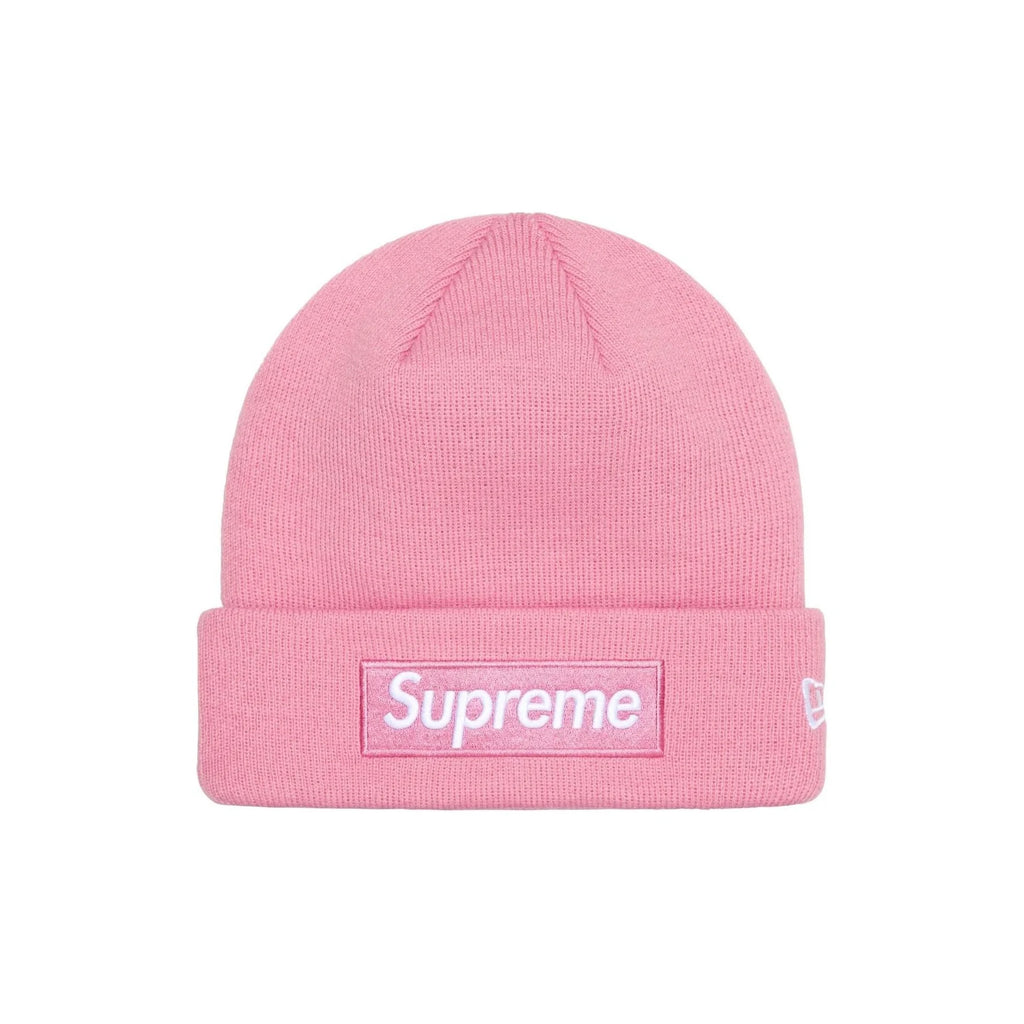 A pink ribbed knit beanie hat featuring a white Supreme box logo patch on the front cuff and a small white New Era flag logo on the side, set against a plain white background.