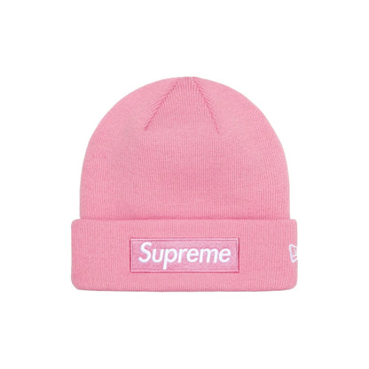 A pink ribbed knit beanie hat featuring a white Supreme box logo patch on the front cuff and a small white New Era flag logo on the side, set against a plain white background.