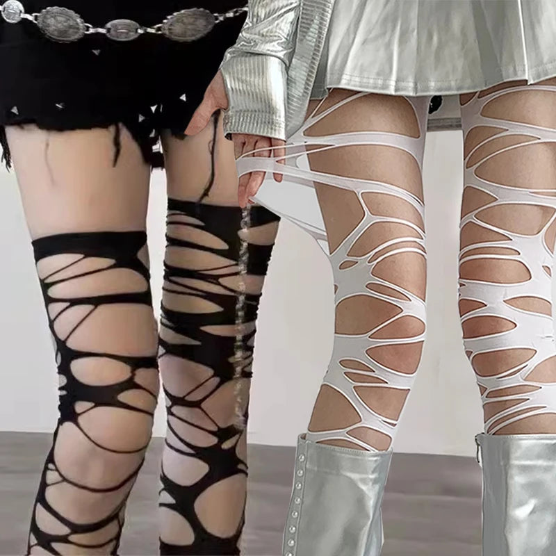 Two pairs of legs wearing sheer patterned stockings with metallic shoes.