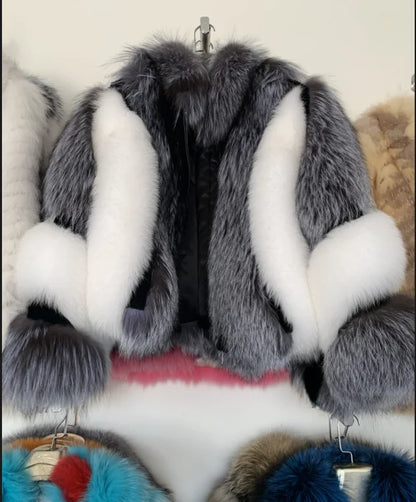 Fur coat with white and gray fur trim on a rack.
