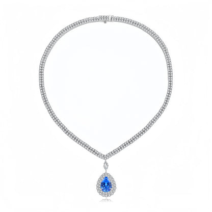 A silver-toned diamond necklace with a teardrop-shaped blue gemstone pendant, displayed on a clean white background.