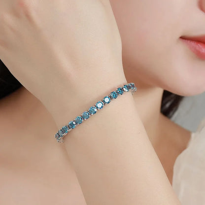Close-up of a woman wearing a blue gemstone bracelet on her wrist.