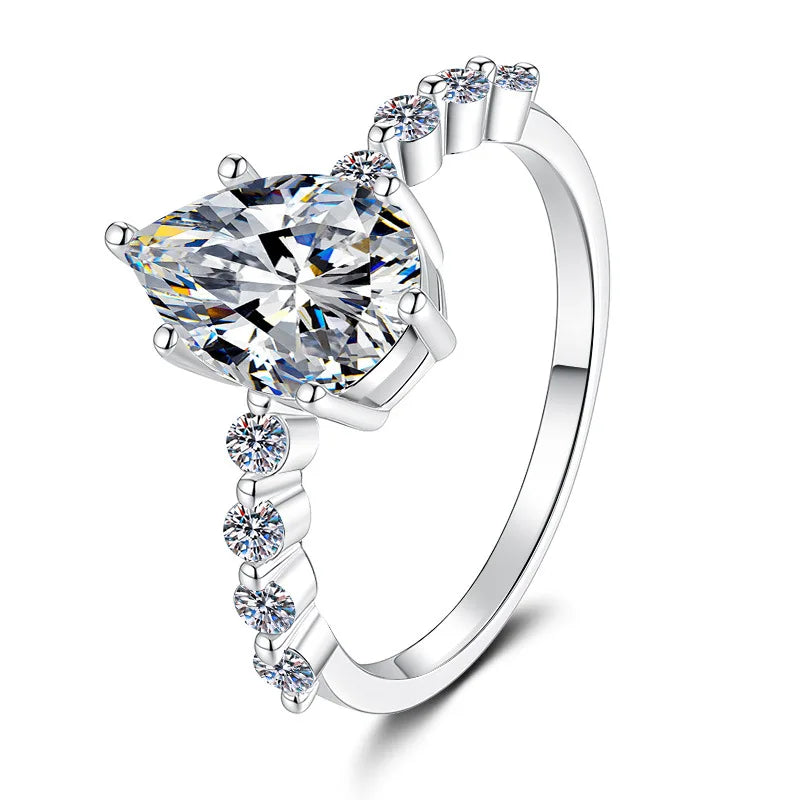 A silver-tone ring featuring a large marquise-cut clear gemstone in a prong setting, with smaller round-cut stones along the shoulders of the band, shown on a clean white background.