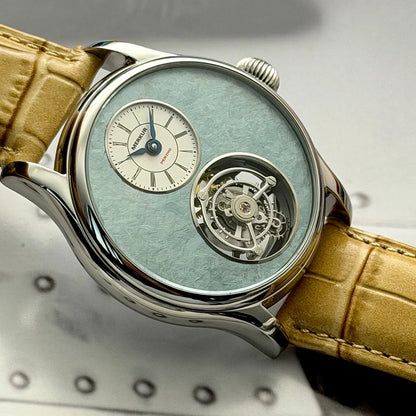 Luxury watch with a detailed face and brown leather strap on a metallic surface