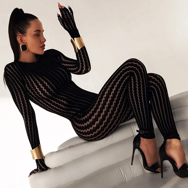 Woman wearing a black and gold patterned outfit sitting on a white surface.
