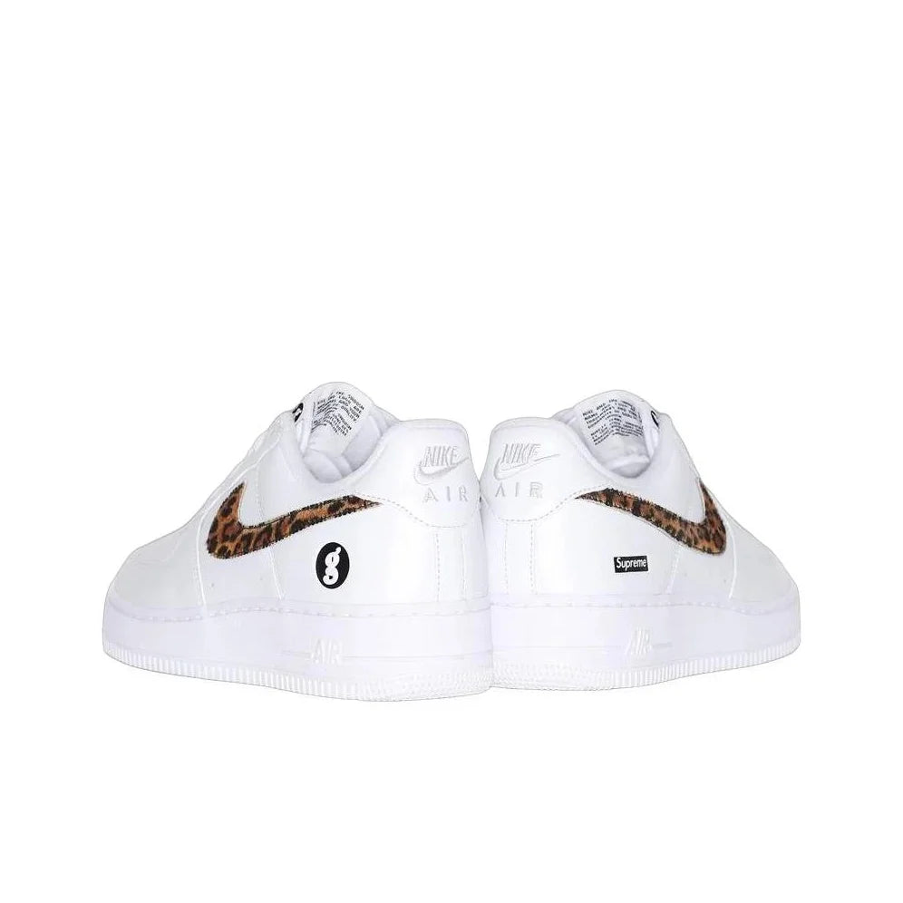 A pair of white Nike Air Force 1 Low sneakers featuring a brown and black leopard print Swoosh and a black circular 8-balls logo on the side, with a small black Supreme box logo on the heel.