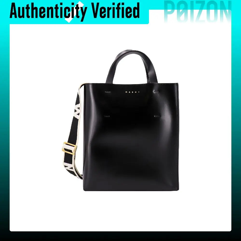 A black leather tote bag with double top handles and a detachable shoulder strap featuring a white and black patterned section with gold hardware, shown against a white background with a teal border.