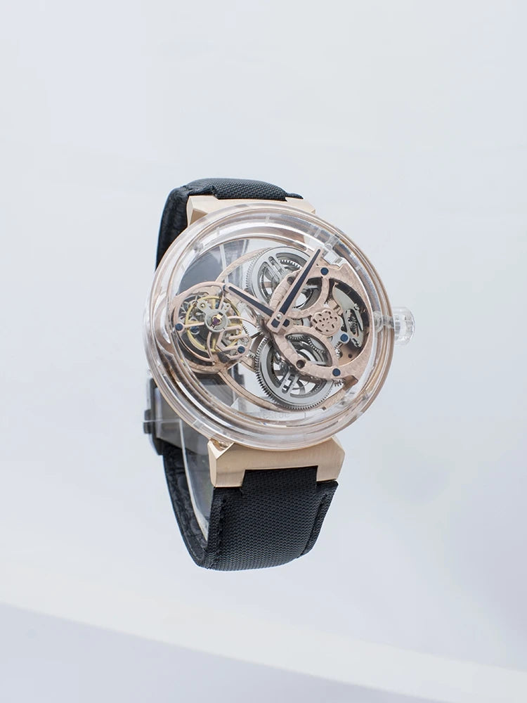 A luxury skeleton watch with a rose gold case, transparent dial showing intricate inner gears, and a black textured strap, photographed against a clean white background.