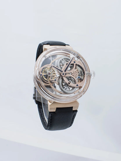 A luxury skeleton watch with a rose gold case, transparent dial showing intricate inner gears, and a black textured strap, photographed against a clean white background.