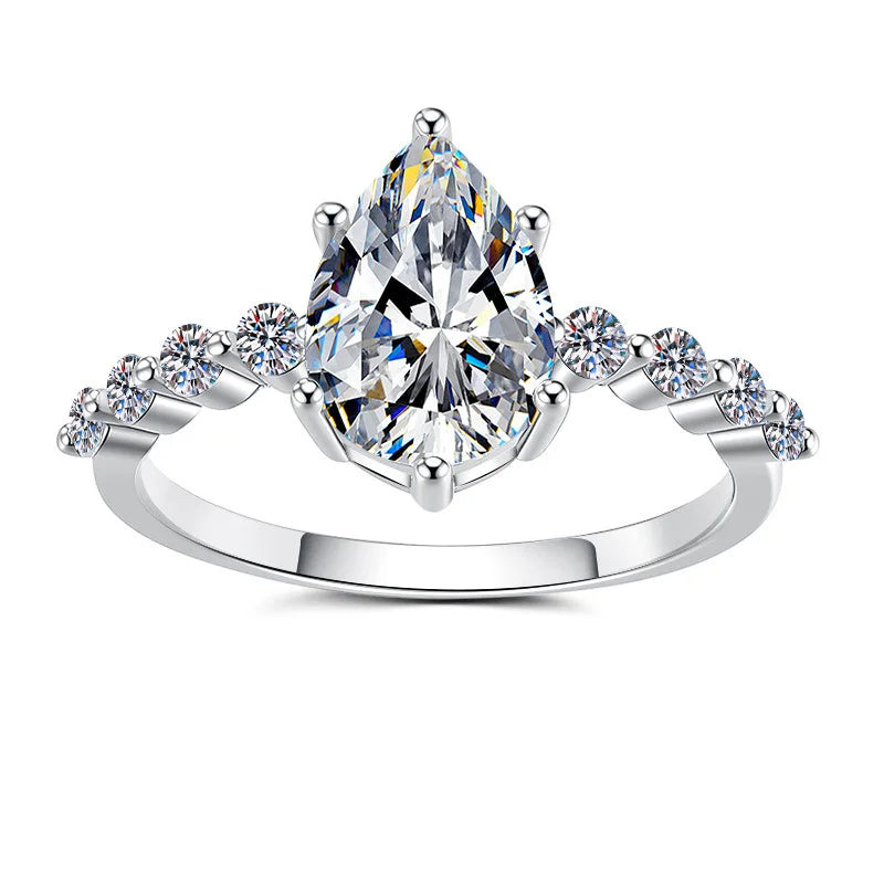 A pear-cut diamond engagement ring in a silver-toned setting with small round diamonds along the shoulders, shown on a plain white background.