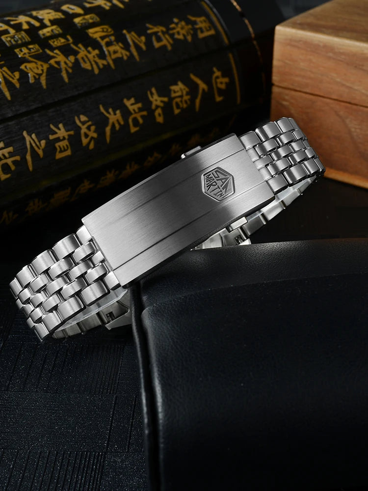 Silver watch strap with brand logo on a dark surface