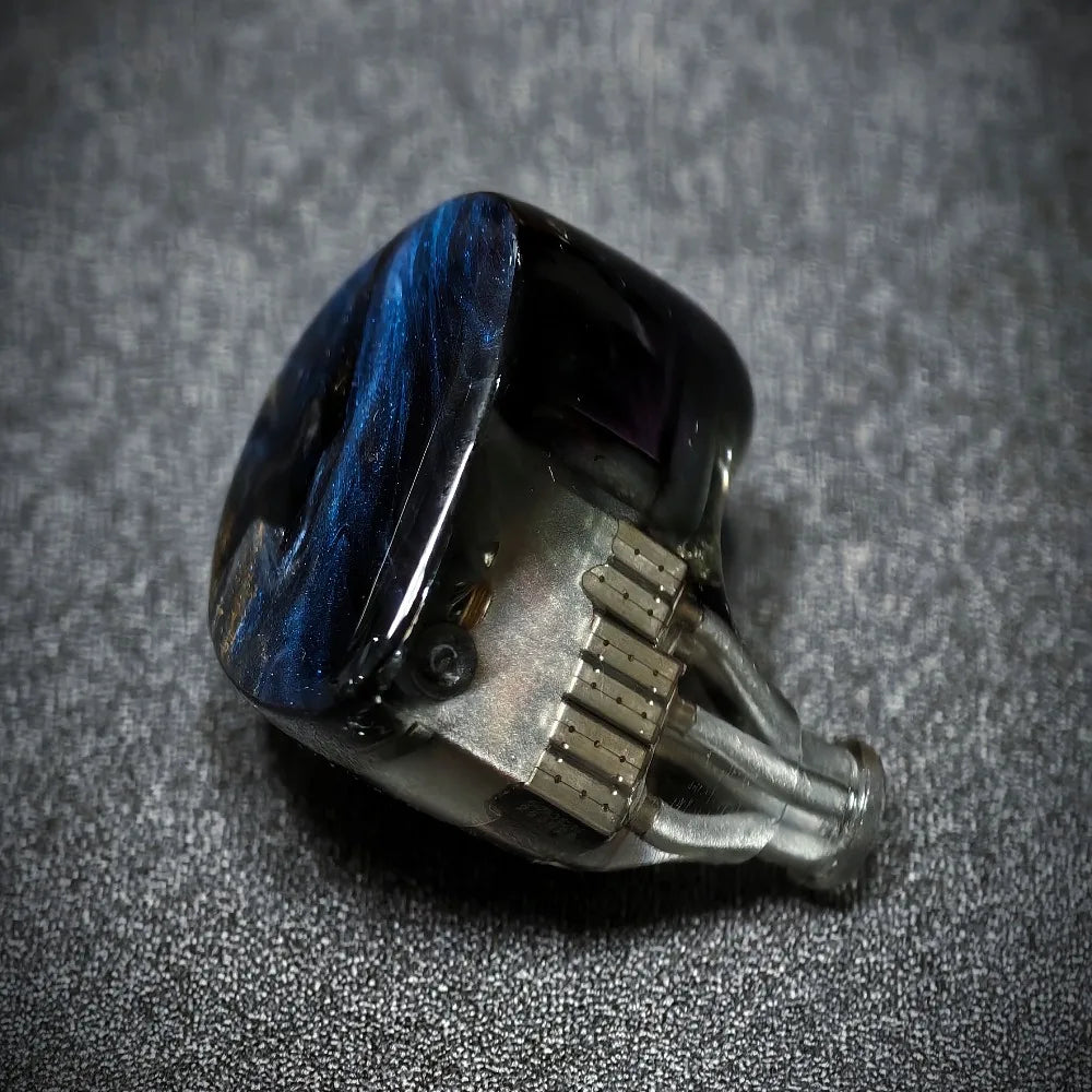 Ring with blue stone and silver band on a textured gray background