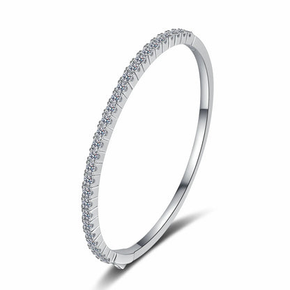 A slim silver-toned bangle bracelet featuring a single row of small clear stones along the outer band, shown on a clean white background.