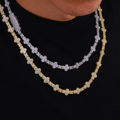 Two layered diamond-encrusted necklaces, one yellow gold and one silver, worn on a model's neck over a black shirt.