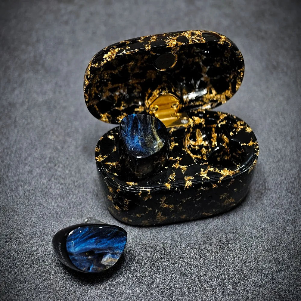 Black and gold decorative box with a blue gemstone on a gray background