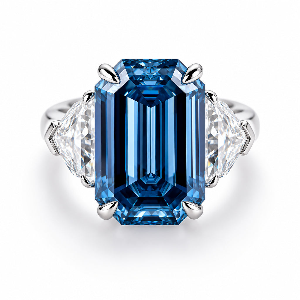 A halo-style moissanite ring featuring a large rectangular blue moissanite center stone with two clear accent stones on either side, set in a silver-colored metal band. The brand logo 'Plc HOLYCOME' is visible in the top left corner.
