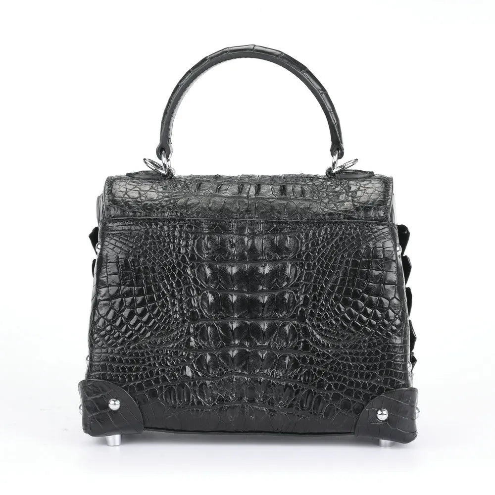A black crocodile-embossed leather handbag with a top handle, silver-tone hardware, and protective metal feet, shown against a plain white background.