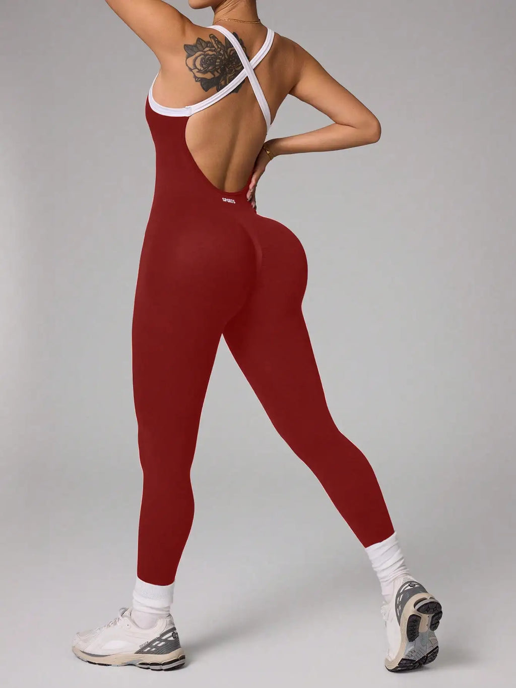 Person wearing a red jumpsuit with white accents on a gray background