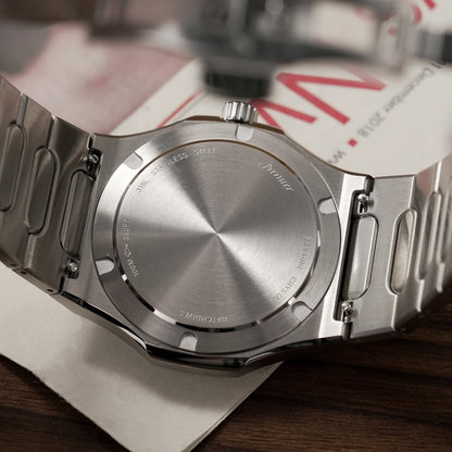 Close-up of a silver watch on a wooden surface with a blurred background