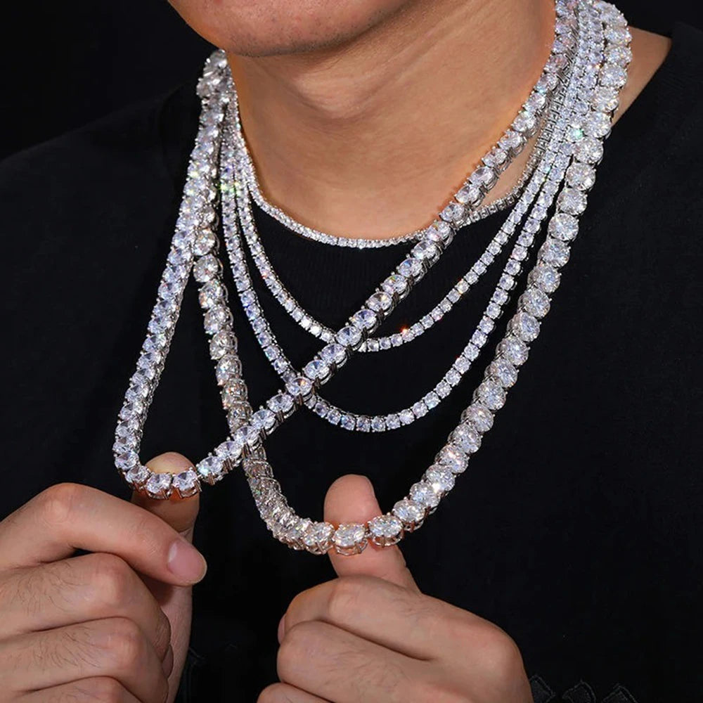 Multiple diamond necklaces being held together against a dark background