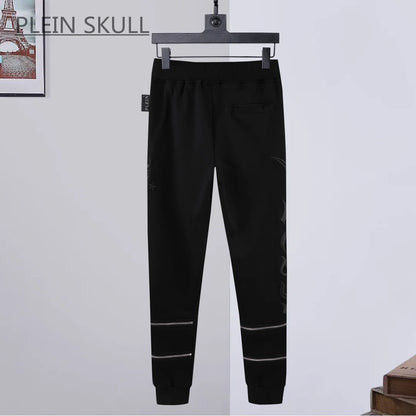 Black pants on a hanger with a white background