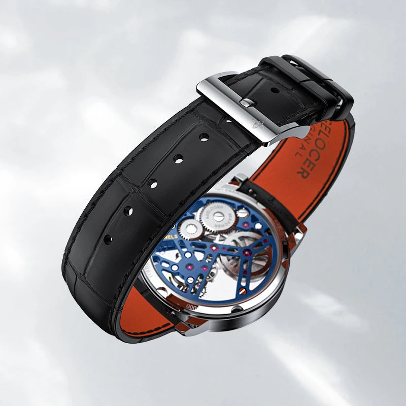Luxury watch with black leather strap and visible mechanical components on a light gray background