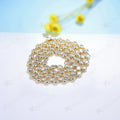 Gold necklace with clear stones on a light blue background