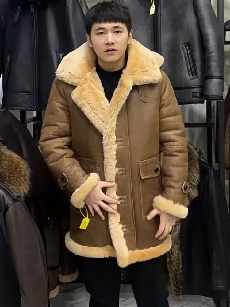 A man wearing a brown shearling-lined jacket with a large beige fur collar, standing in front of a clothing rack filled with black leather jackets.