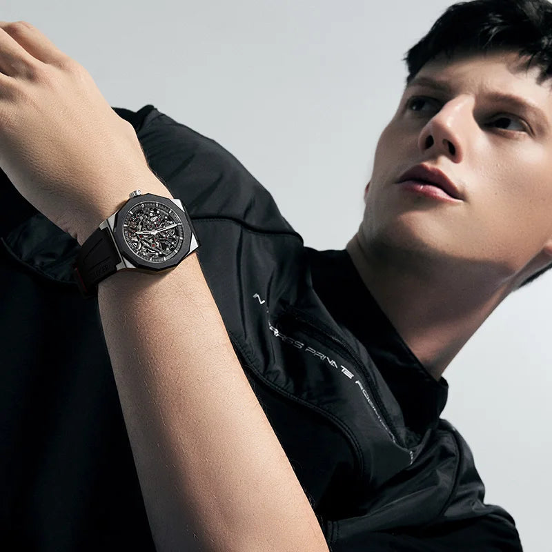 Person wearing a black wristwatch with a blurred background