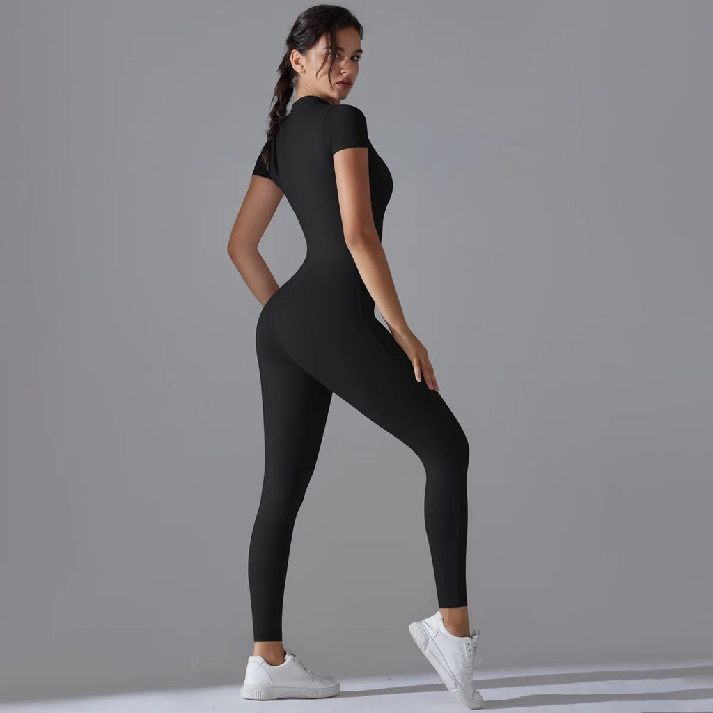 Woman wearing a black bodysuit on a gray background