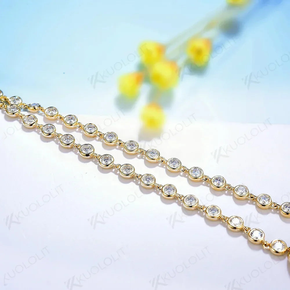 Gold chain with clear stones on a light blue background with yellow flowers.