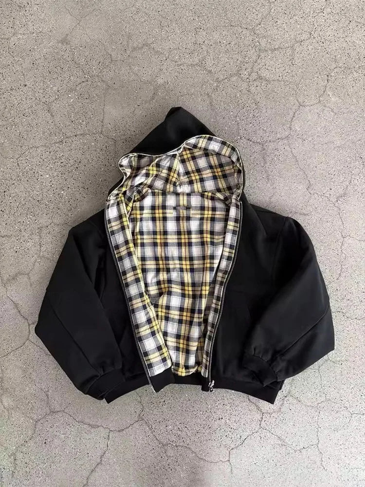 Black jacket with plaid lining on a textured gray surface