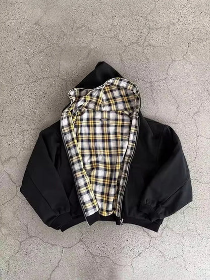 Black jacket with plaid lining on a textured gray surface