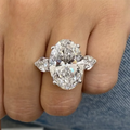 Diamond ring with pear-shaped side stones on a finger