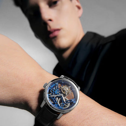 Close-up of a person wearing a detailed wristwatch with a blurred background