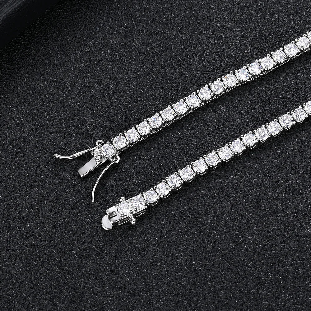A silver tennis bracelet with a row of clear rectangular gemstones, displayed on a textured black background.