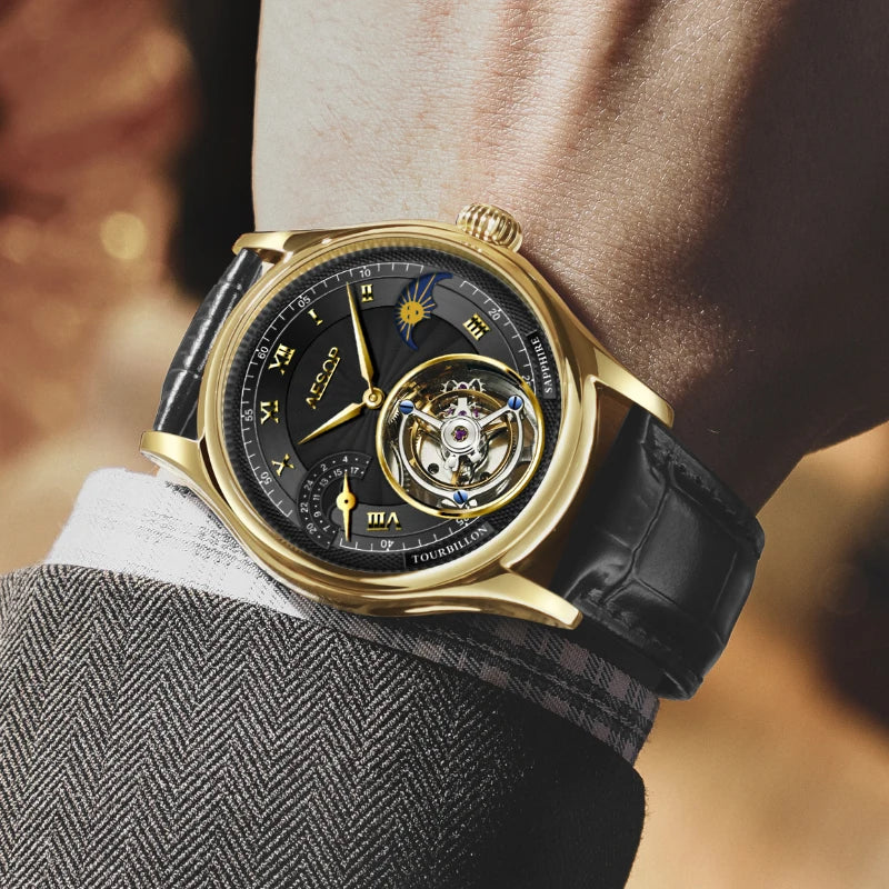 A luxury wristwatch with a gold-tone case, black dial, and black leather strap, shown worn on a person's wrist. The watch features a moonphase indicator and an open-heart tourbillon.