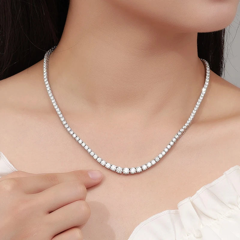 Silver necklace being worn by a person with a neutral background