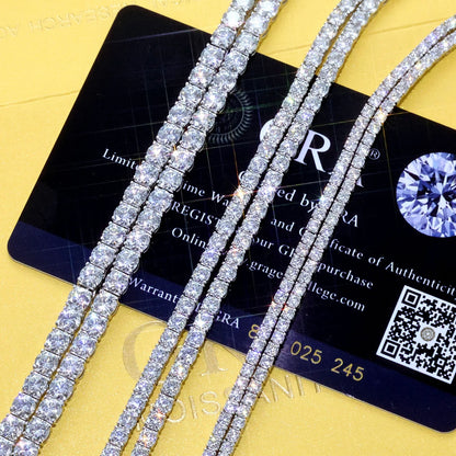 Diamond necklaces on a yellow surface with a GIA card in the background