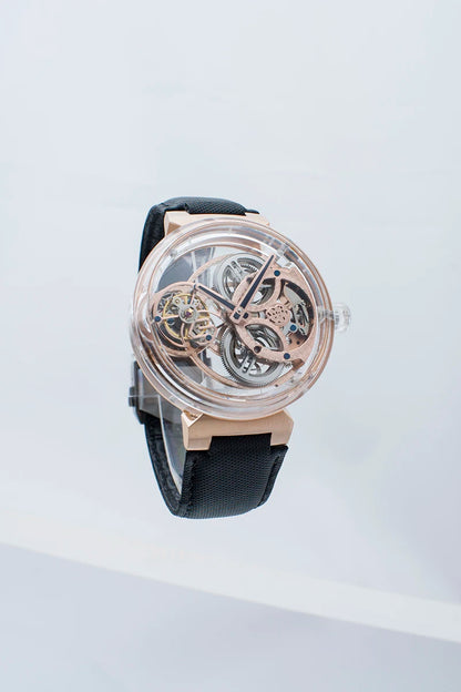 A skeleton watch with a rose gold-tone case and visible mechanical gears, paired with a black strap, shown against a clean white background.