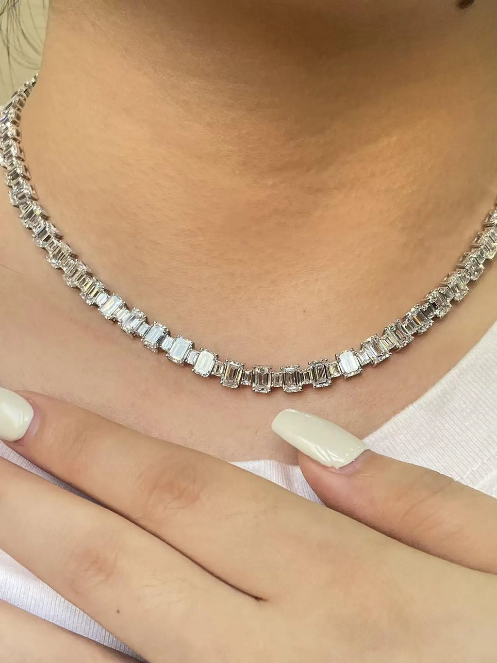 Silver necklace with rectangular stones worn by a person